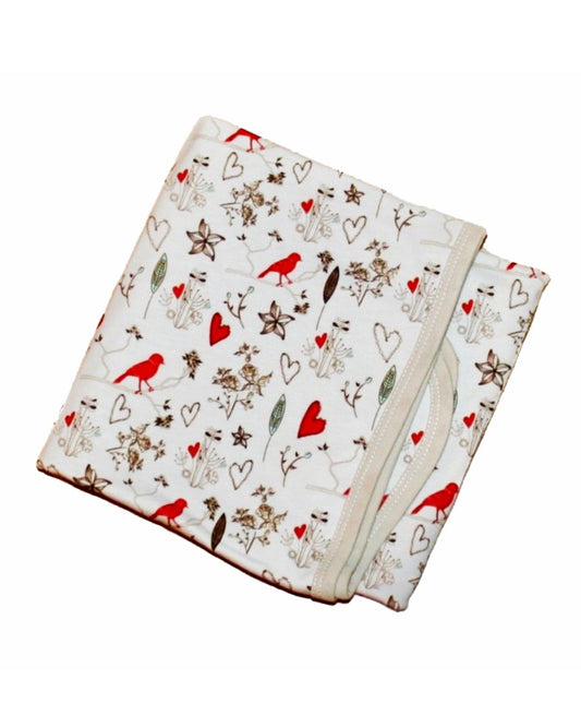 weiße babydecke mit filigranem print in braun & orange aus biobaumwolle Bei juicyfashion 