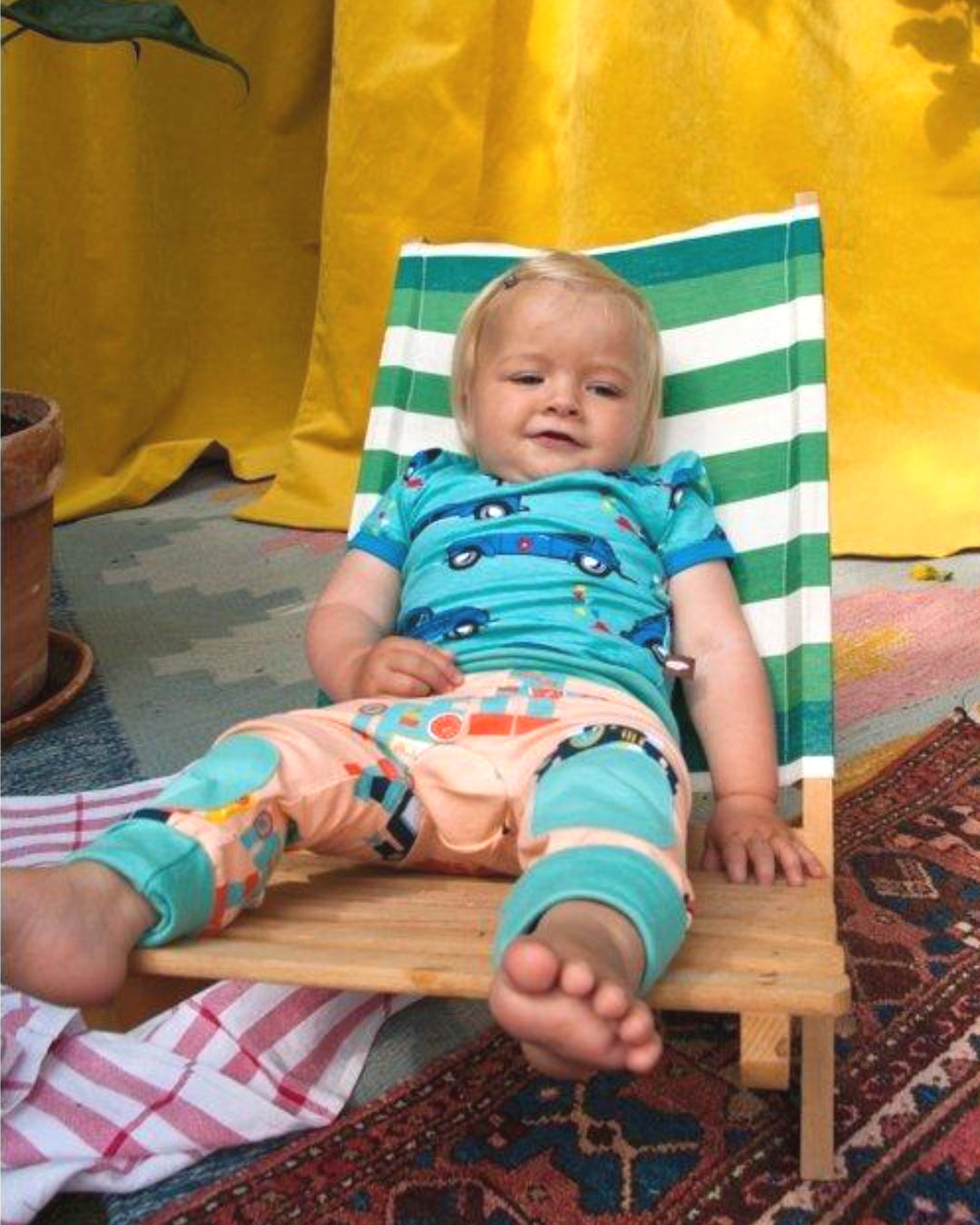 Kind im Liegestuhl mit Kleidung aus Biobaumwolle von moromini