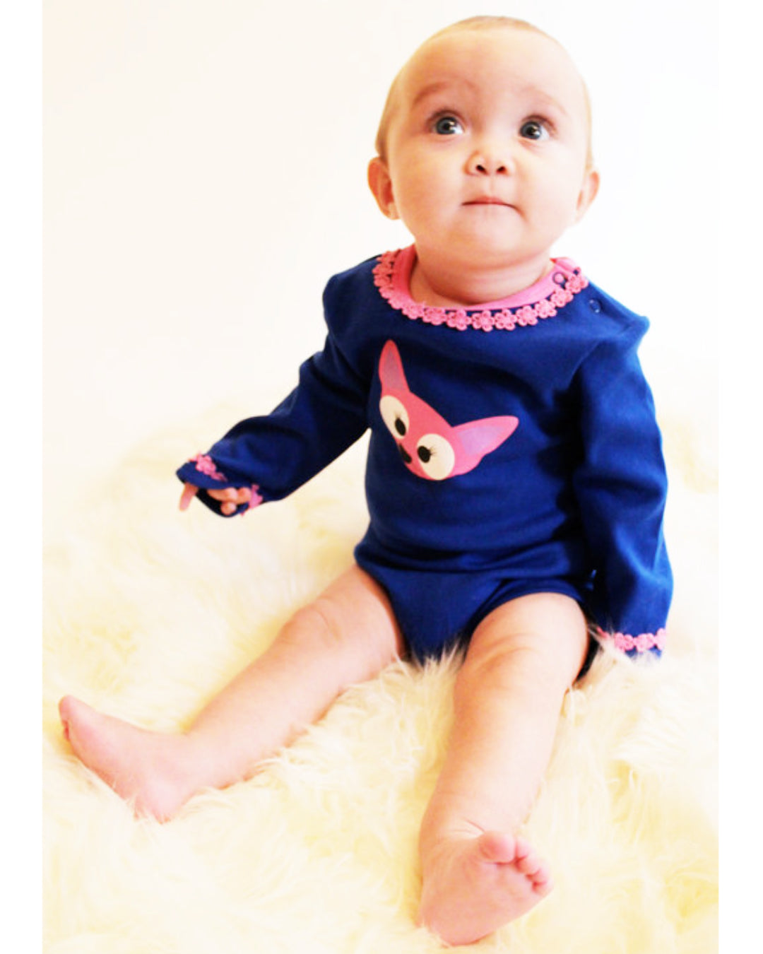 Baby in blauem Langarmbody mit rosa Fuchs