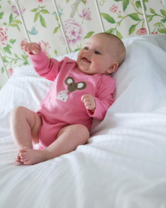 Baby mit rosa Babybody von Frugi