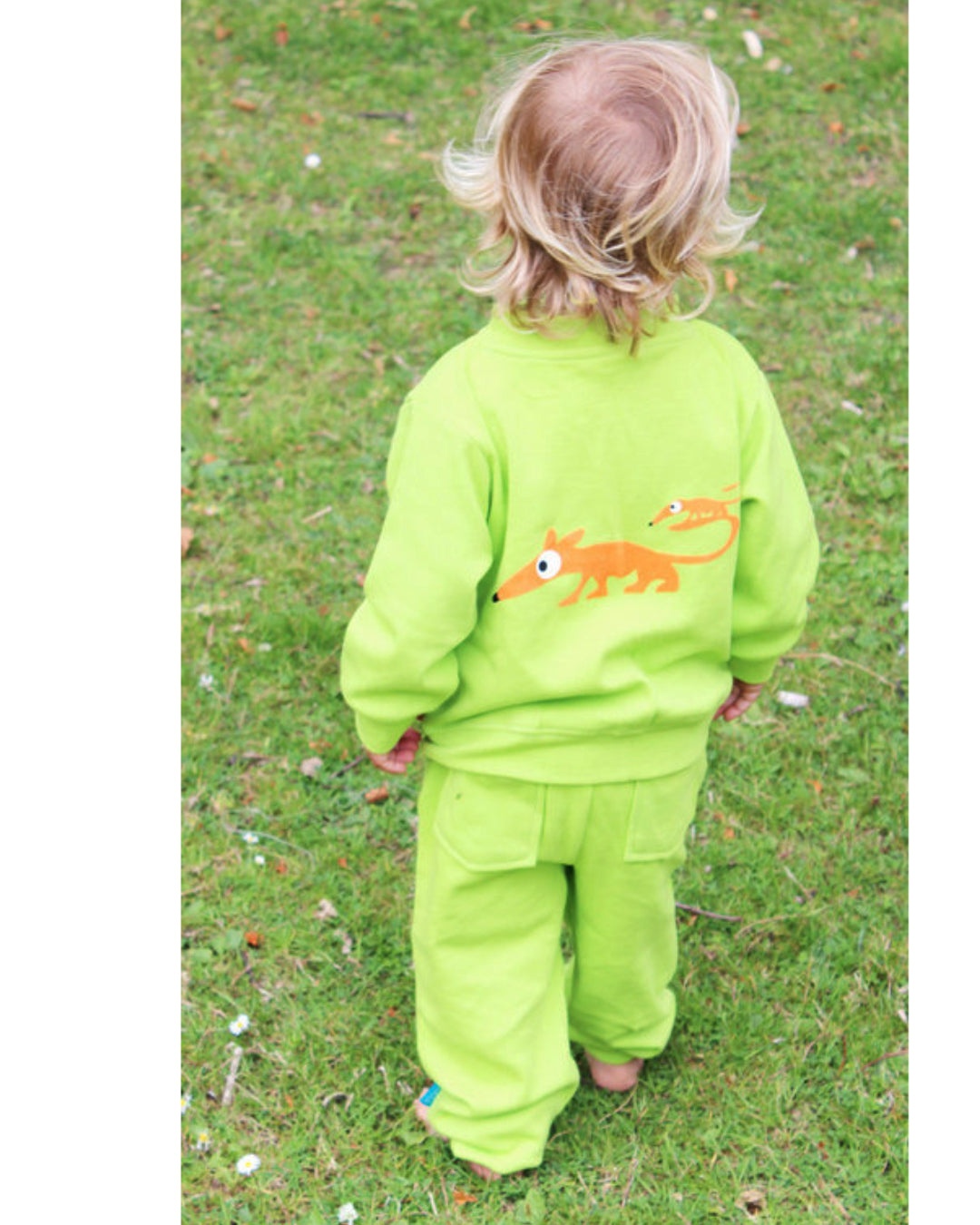 Grüne Jacke mit Reißverschluss und kleinem Dackel Anton in orange