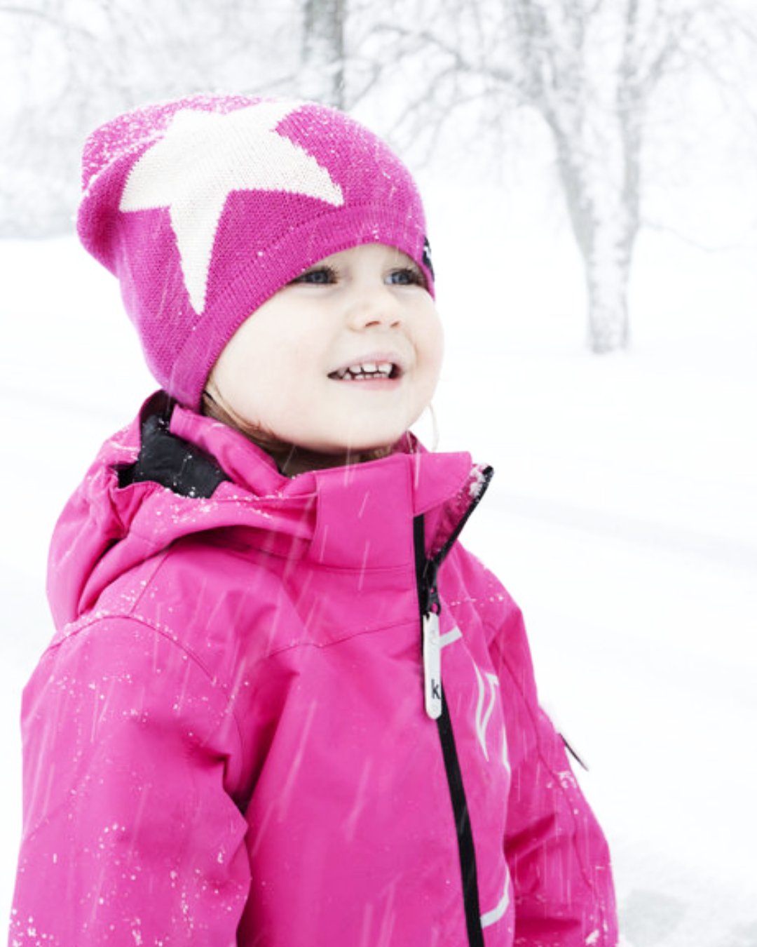Kind im Schnee mit Strickmütze in Pink