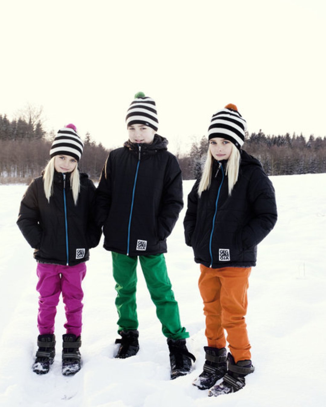 Drei Kinder mit Bommelmützen aus Biowolle