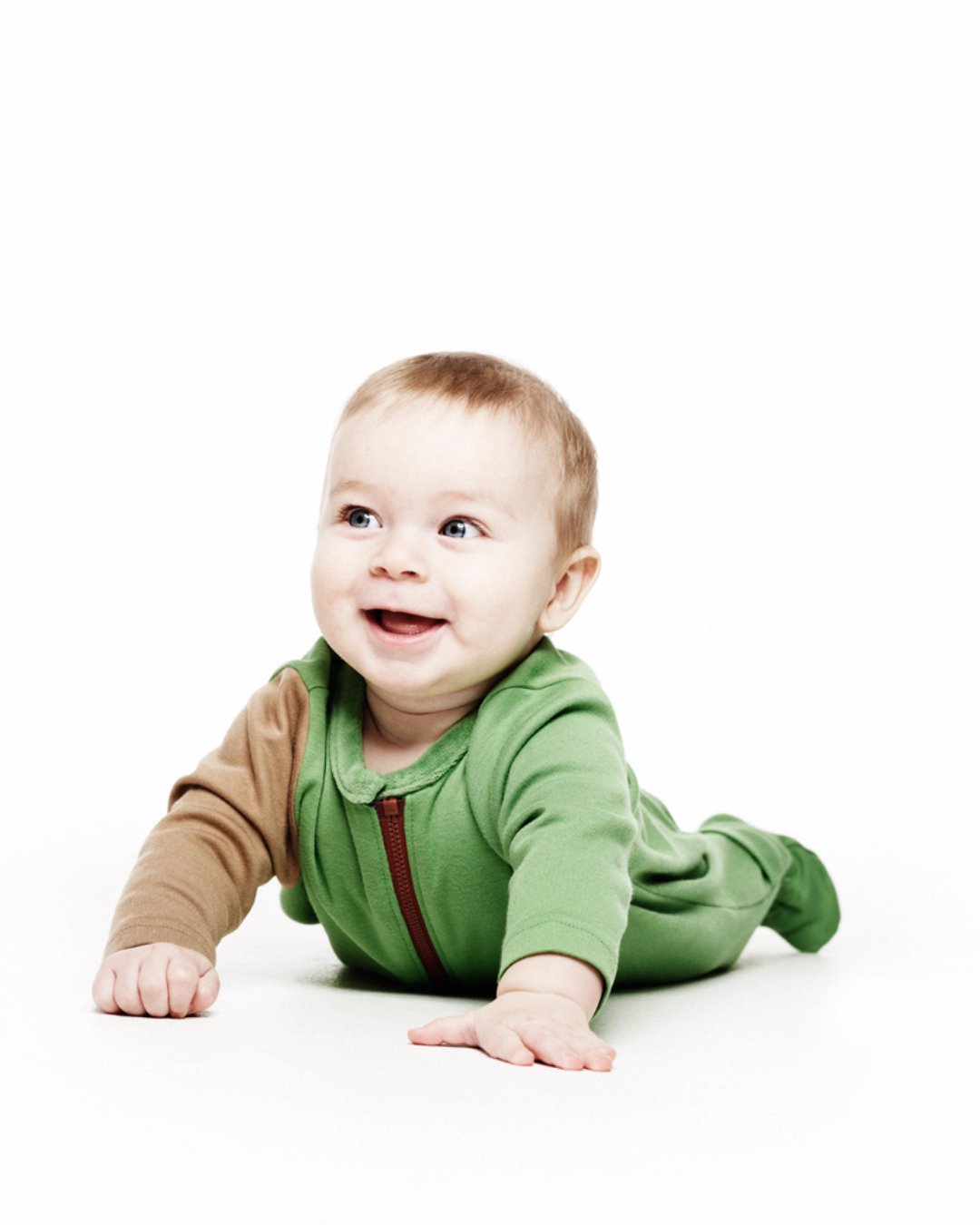 Lachendes Baby mit grünem Overall aus Bambus