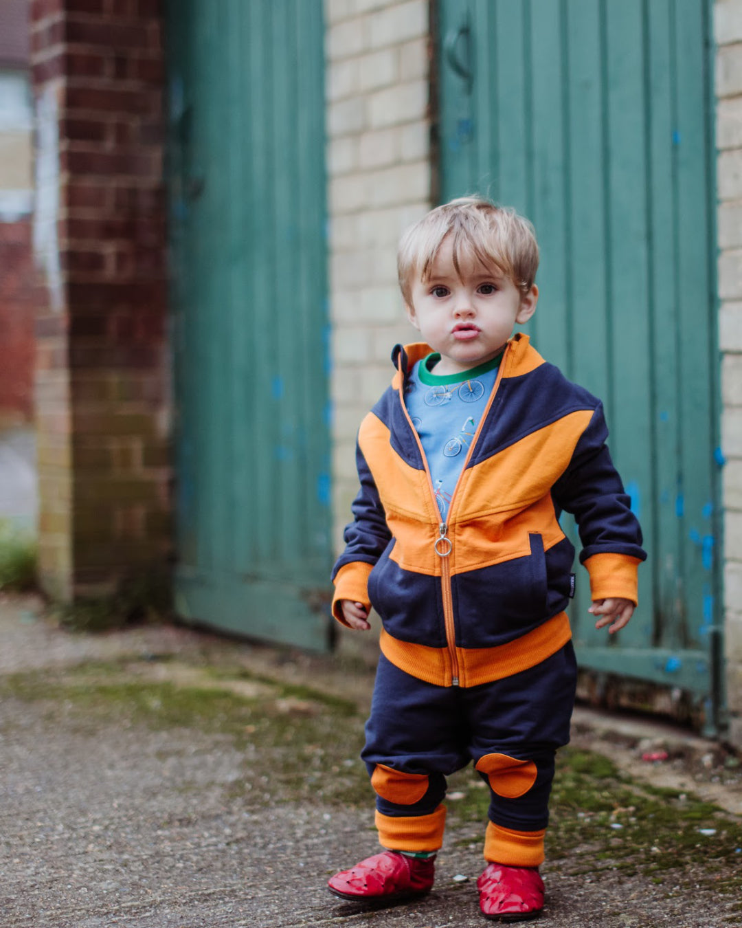 kleines Kind mit Retro Anzug von moromini in dunkelblau orange