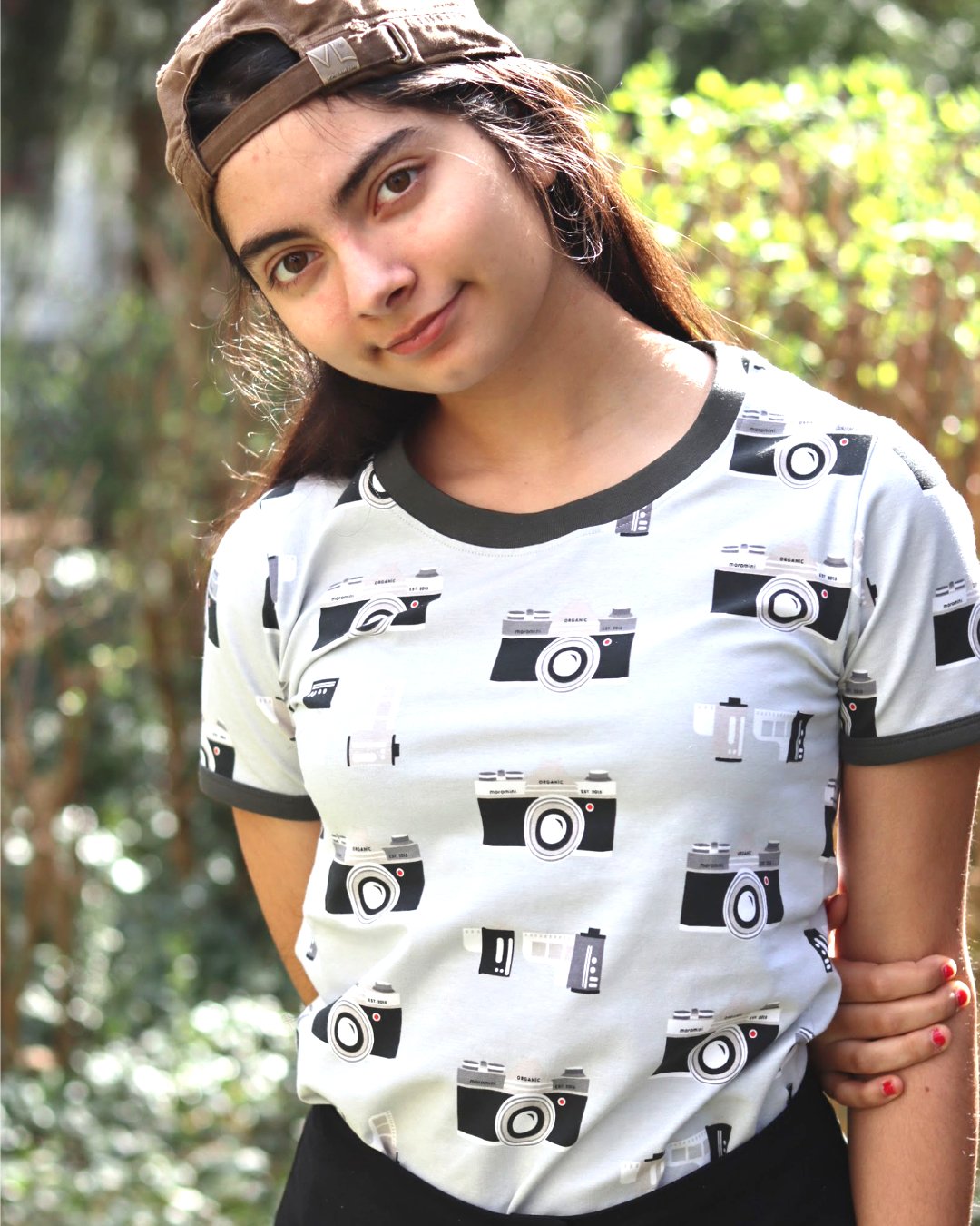 Mädchen mit silbergrauem T-Shirt und Retro Fotoapparate und Filmrollen von moromini